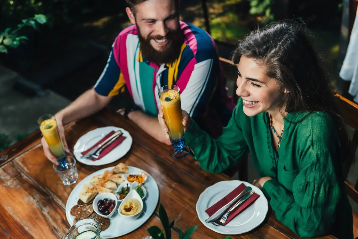 A couple sharing an outdoor brunch with fresh juice