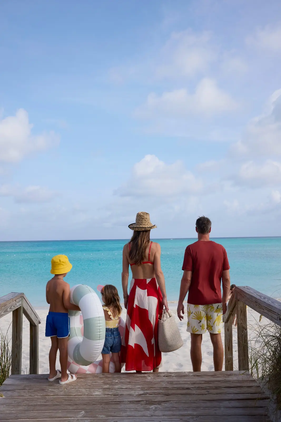 A family walking down a boardwalk toward the beach at Beaches Turks & Caicos