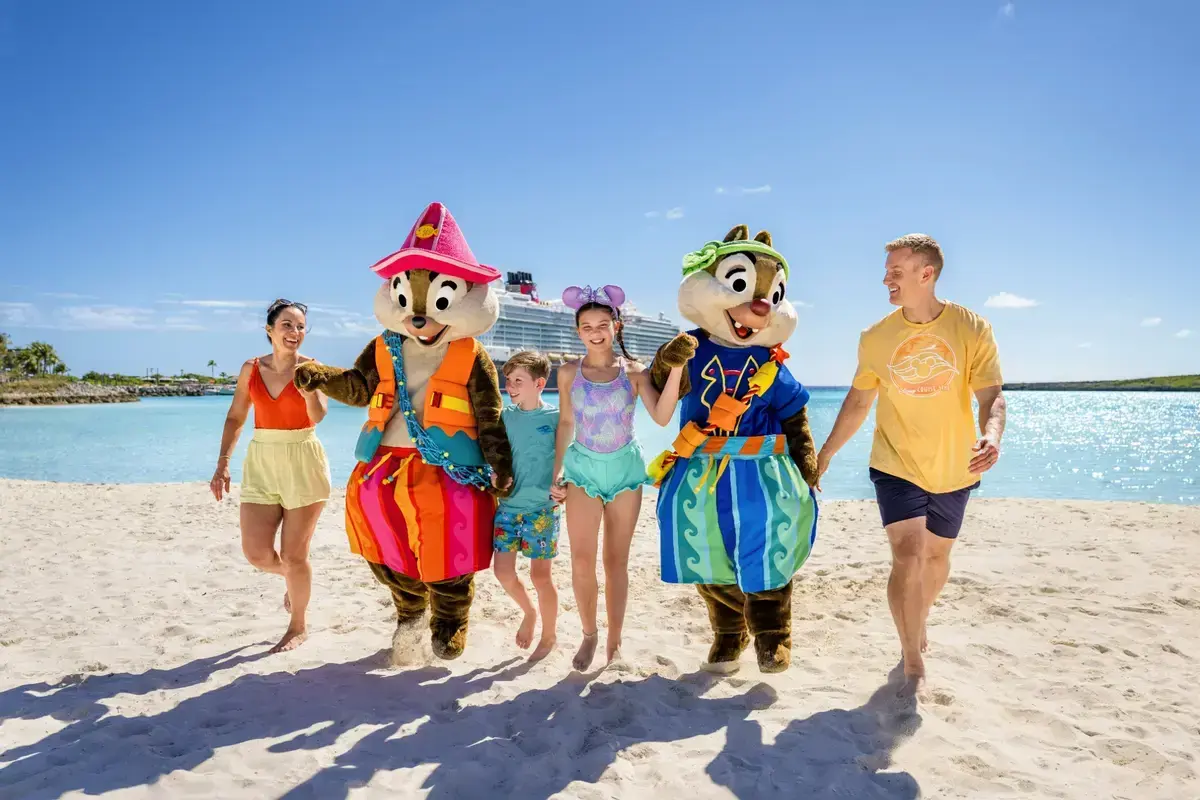 A family with Disney characters on the beach at Castaway Cay.