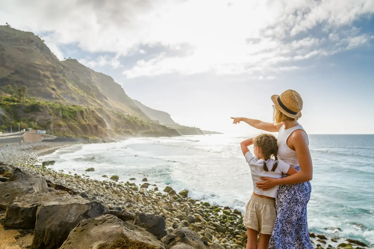 A mother and child exploring a rocky coastline together