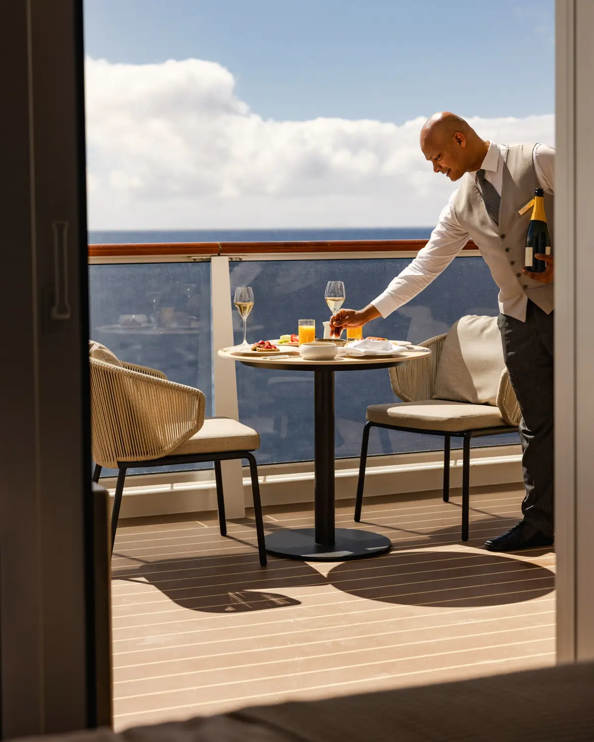 A host setting a table on a private terrace overlooking the sea
