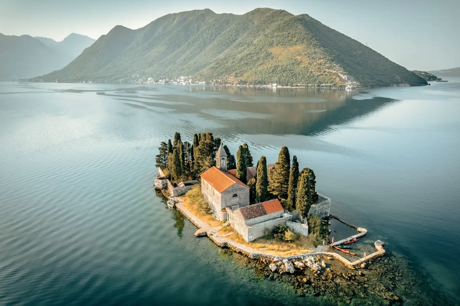 An island church framed by still water and steep green mountains