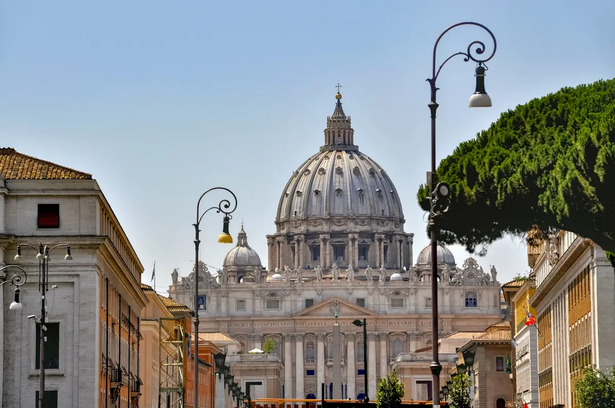 St. Peter’s Basilica framed by buildings and trees in Rome