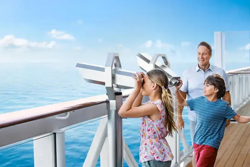 A family looking out to sea from a Norwegian ship’s promenade.