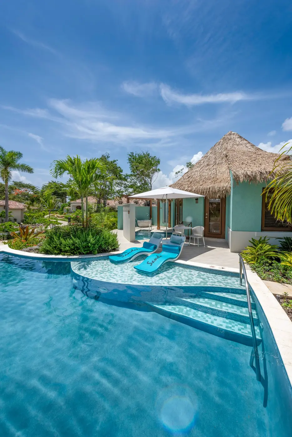 A quiet pool beside a thatched Rondoval suite at Sandals Dunn’s River