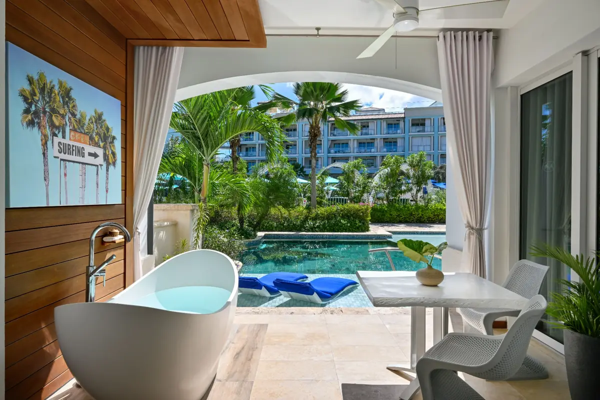 A Sandals Royal Barbados suite terrace with a soaking tub and pool view
