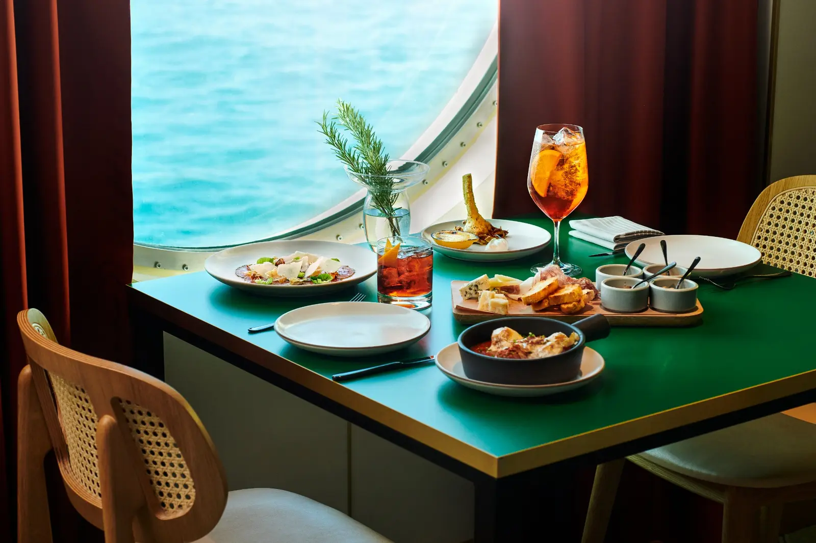 Italian dishes and drinks beside an ocean-view window at Extra Virgin.