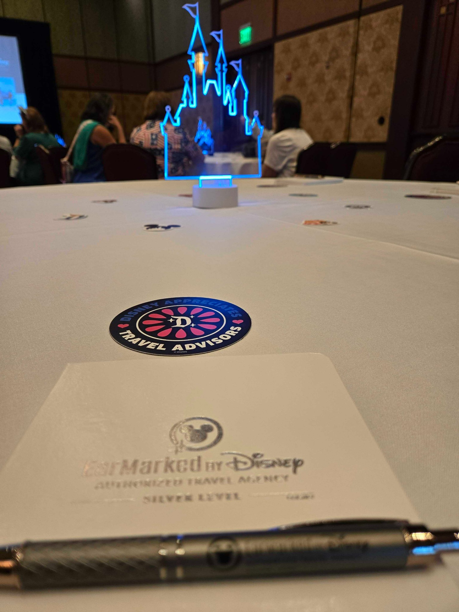 EarMarked by Disney notebook and pen on a table during an advisor training session.